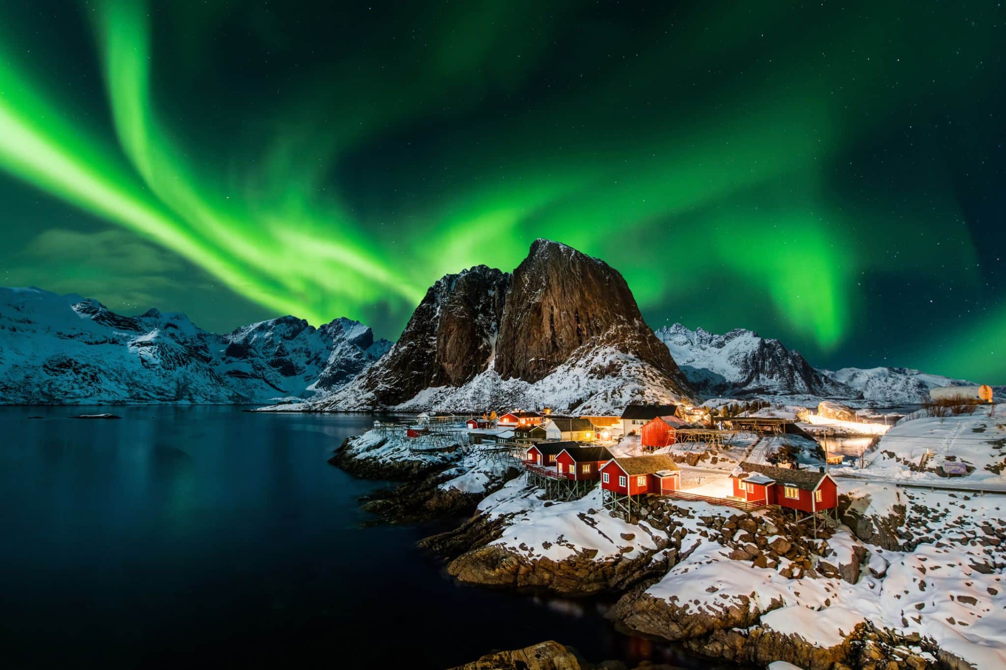 The northern lights over a snowy fishing village in northern Norway
