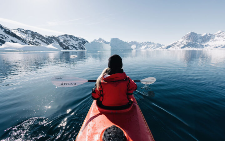 Kayaking beside Le Commandant Charcot among the Arctic ice