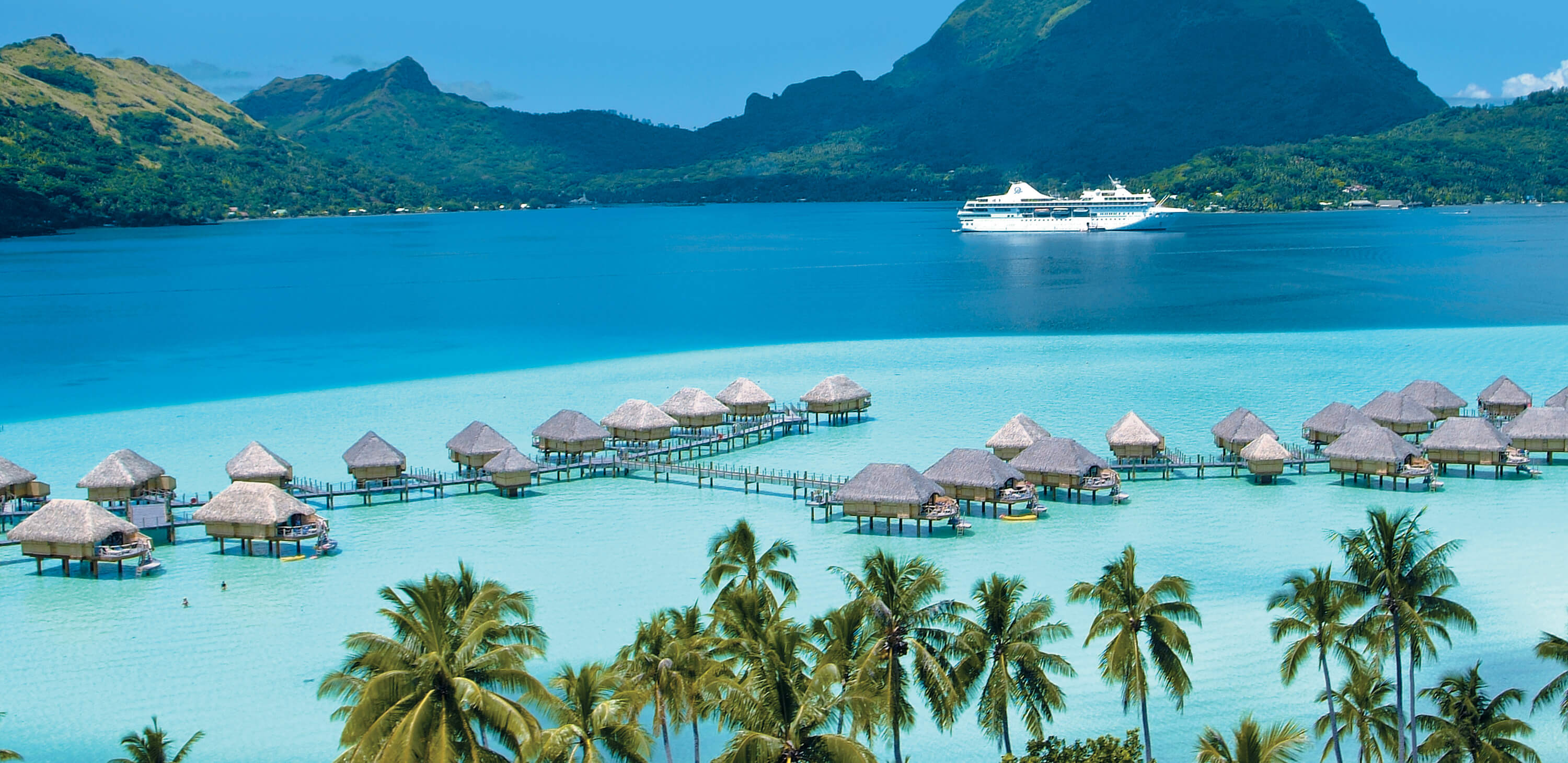 Overwater bungalows on a turquoise lagoon in French Polynesia