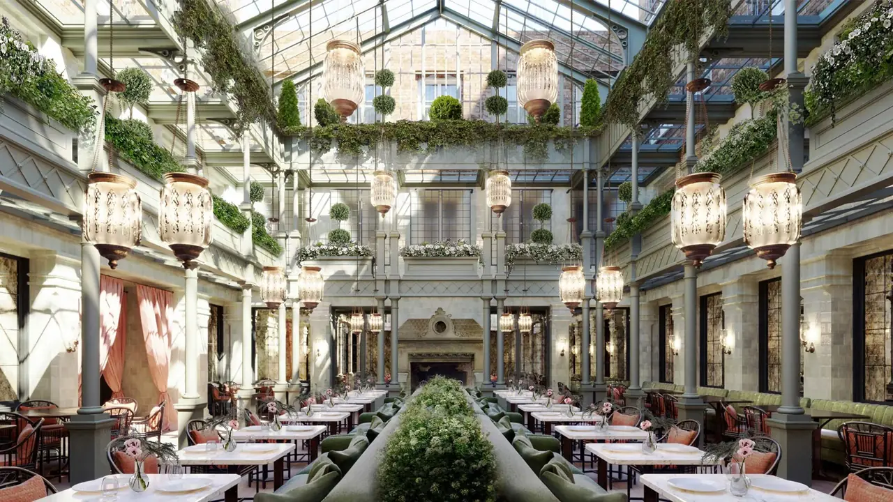The glass-roofed atrium restaurant at NoMad London, with hanging lanterns and greenery