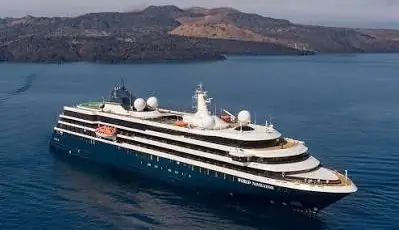 An Atlas Ocean Voyages ship off a volcanic island