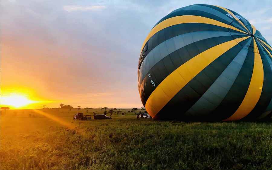 A hot air balloon inflating on the plains before dawn
