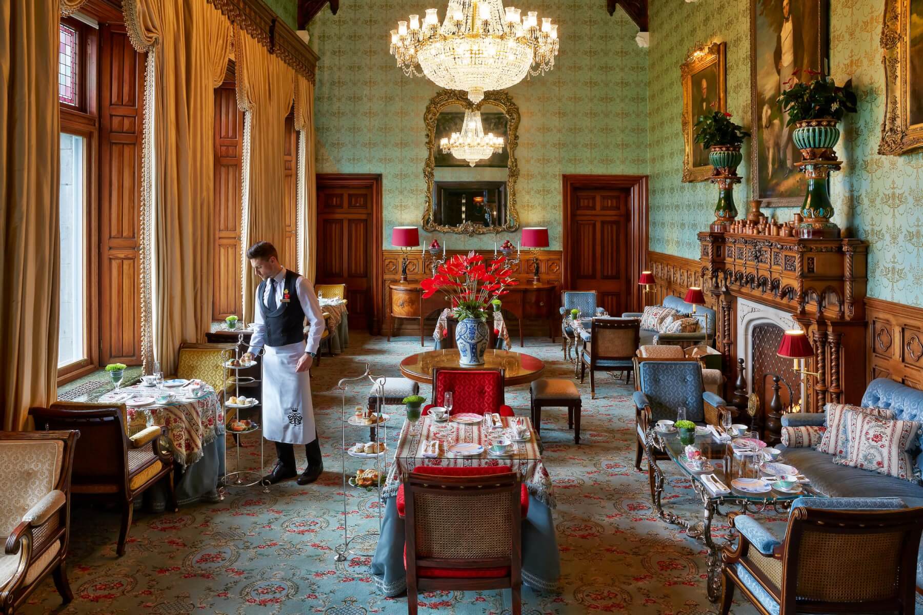Afternoon tea being served in the Connaught Room beneath crystal chandeliers