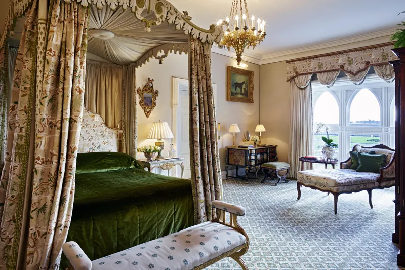 A four-poster bed beneath a chandelier in one of the castle suites