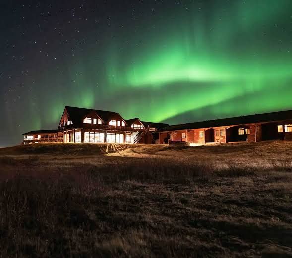 Hotel Rangá at night beneath a green aurora