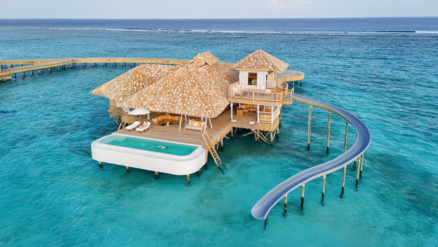 An overwater villa with a waterslide into the Indian Ocean