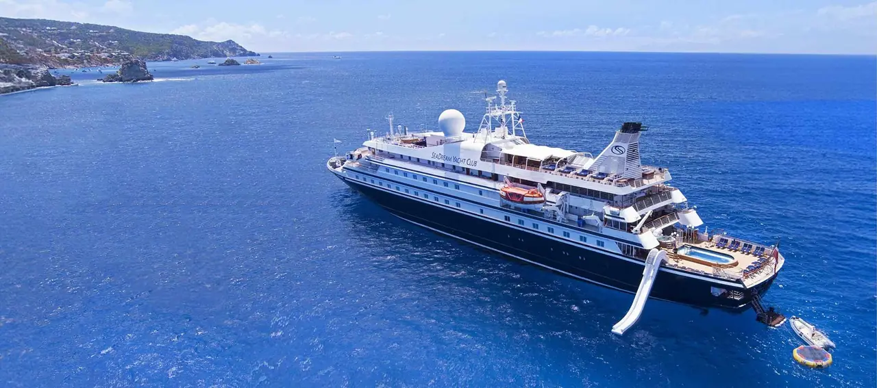 A SeaDream yacht at anchor with its water slide and marina open