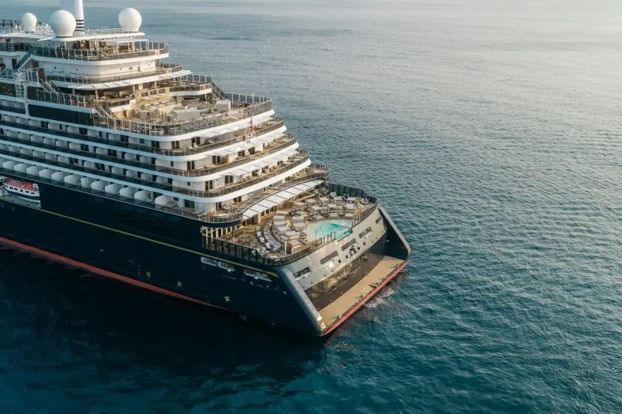 An Explora Journeys ship at sea, with its stern infinity pool and terraces