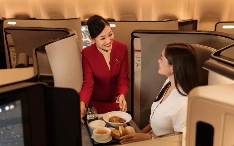 Cathay Pacific cabin crew serving a Business Class guest