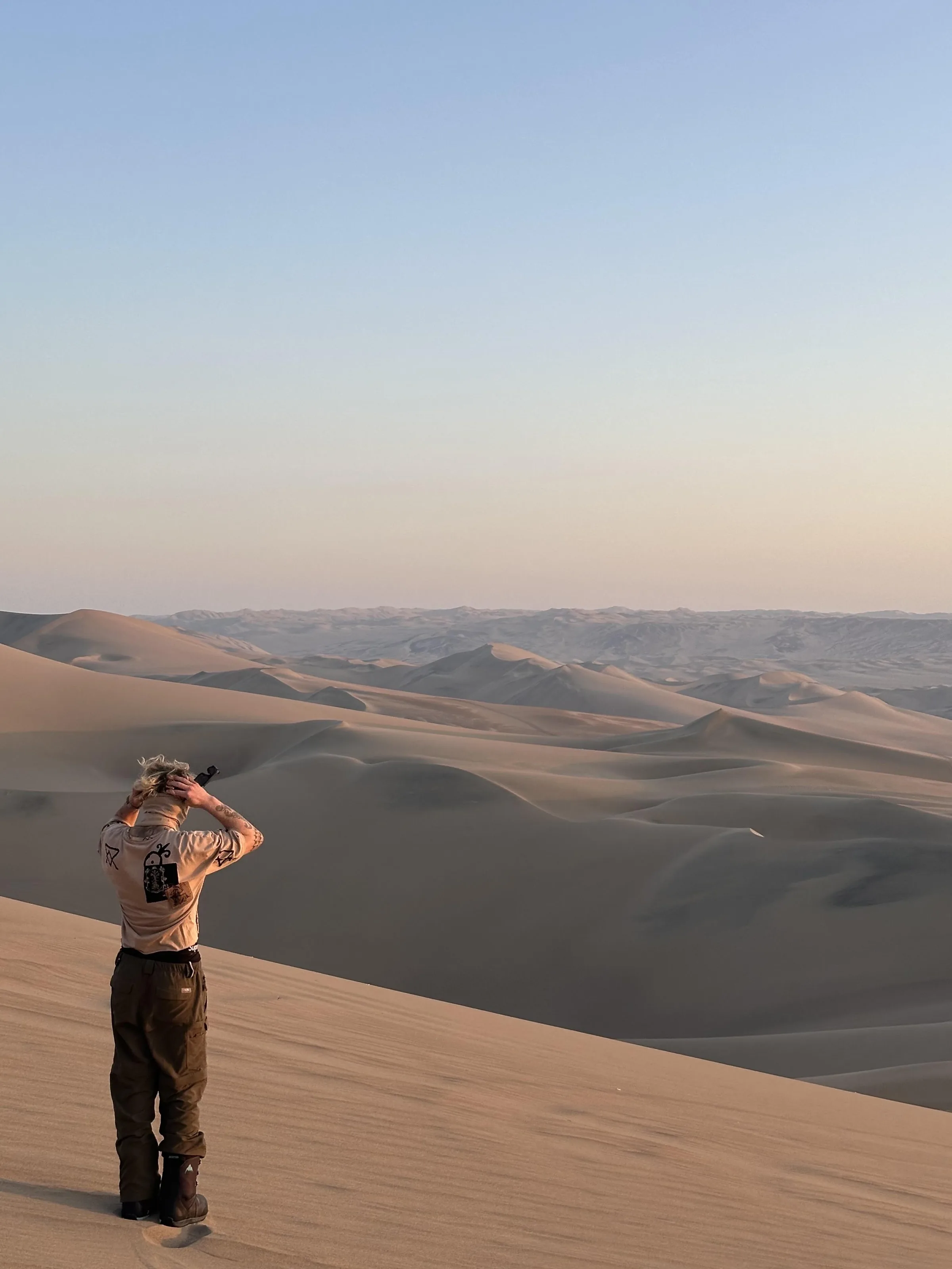 A Frontier advisor taking in a sea of desert dunes at golden hour